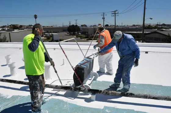 NuShake roofing crew applying a protective coating to a commercial roof